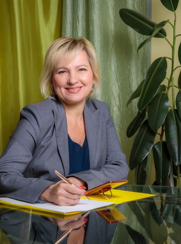 an-attractive-middle-aged-woman-director-is-sitting-at-a-table-in-the-office-filling-out-document.jpg