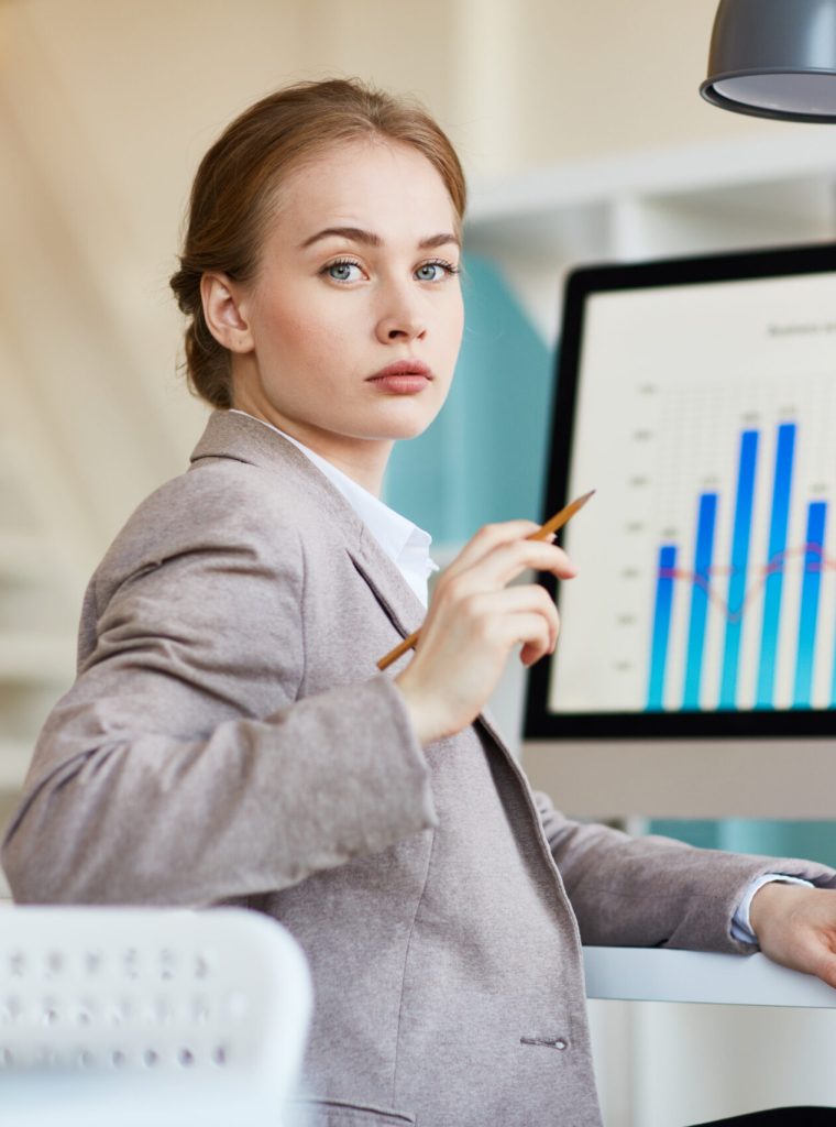 Confident analyst looking at camera during online research of financial development